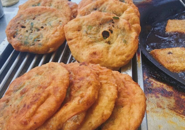 重庆美女路边卖葱油饼,5元一个,现做现吃,客人排队来买